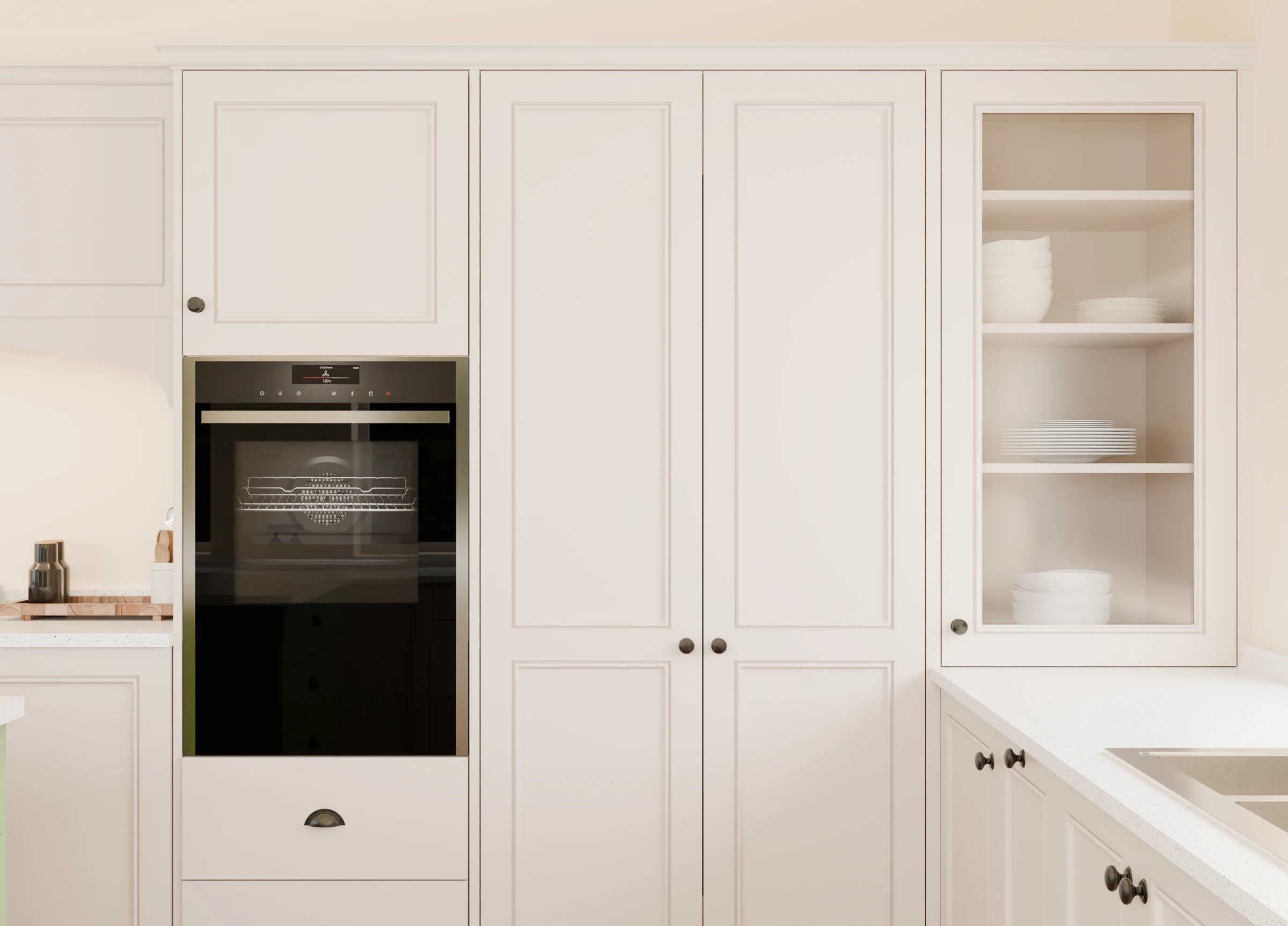 Warm white kitchen cabinetry with bronze handles and an integrated oven